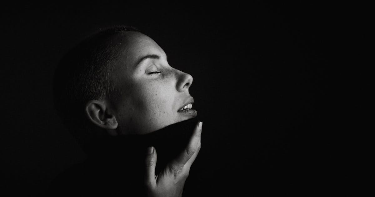 Monochrome portrait of a person with closed eyes, representing subtle body language and perception