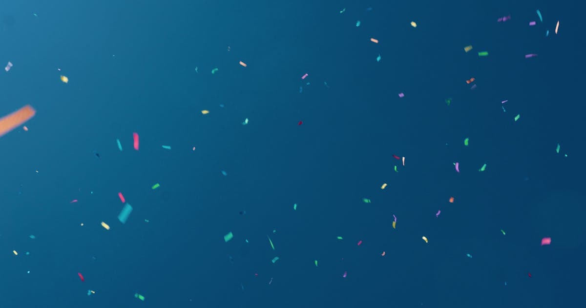Colorful confetti on blue background celebrating World Rock Paper Scissors Day